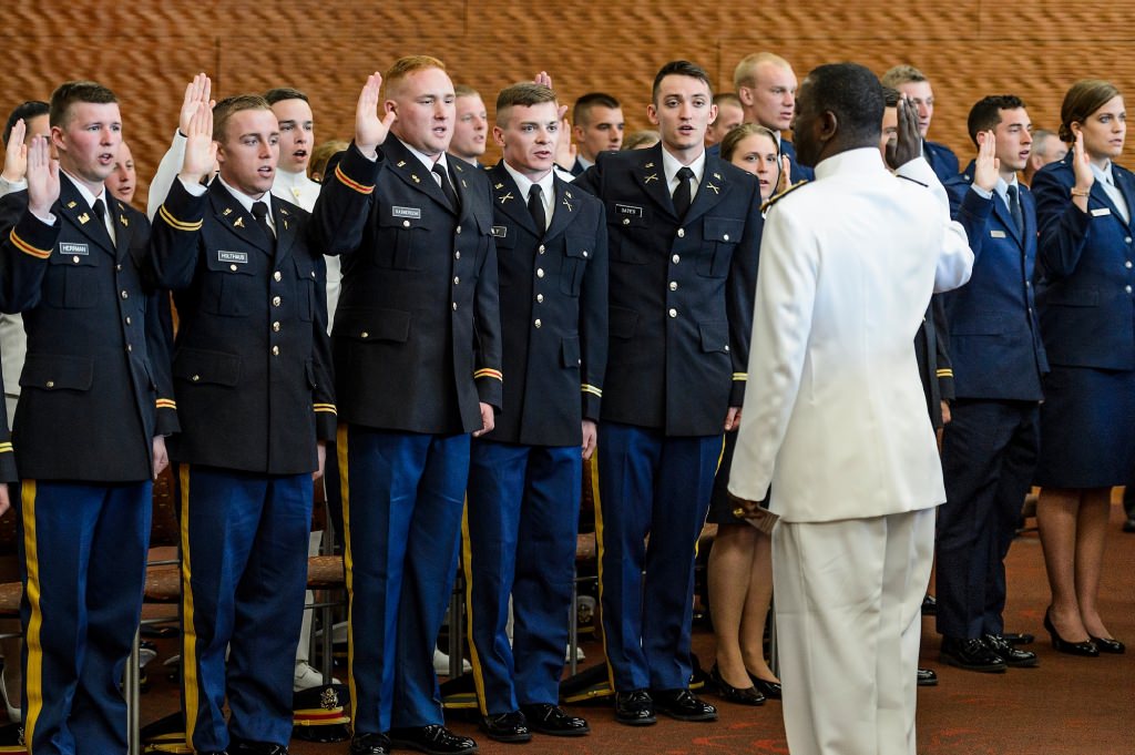 Led by Rear Adm. Stephen C. Evans, commander of the U.S. Naval Service Training Command, right, members of UW-Madison's Army, Navy and Air Force Reserve Officer Training Corps take the oath of office during a ceremony Saturday. The event formally recognized 32 graduates from UW-Madison as officers in the military.