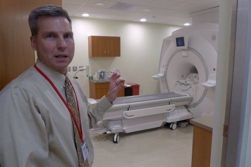 Frank Korosec, a professor of radiology, with a combination MR-PET scanner that is used for patient diagnosis in the morning and research in the afternoon.