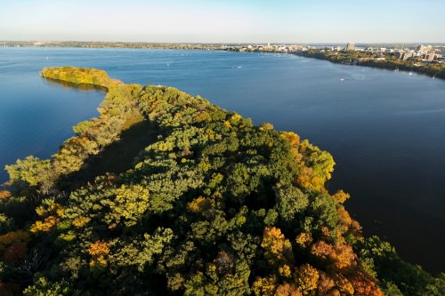 Picnic Point and Lake Mendota are pictured in an aerial view of the University of Wisconsin–Madison campus during an autumn sunset on Oct. 5, 2011. On the horizon is the downtown Madison skyline, right of center, and central UW–Madison campus, at far right. The photograph was made from a helicopter looking southeast. (Photo by Jeff Miller/UW-Madison)