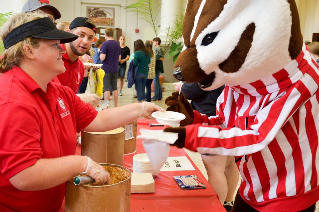 Bucky Badger being served a dish of ice cream