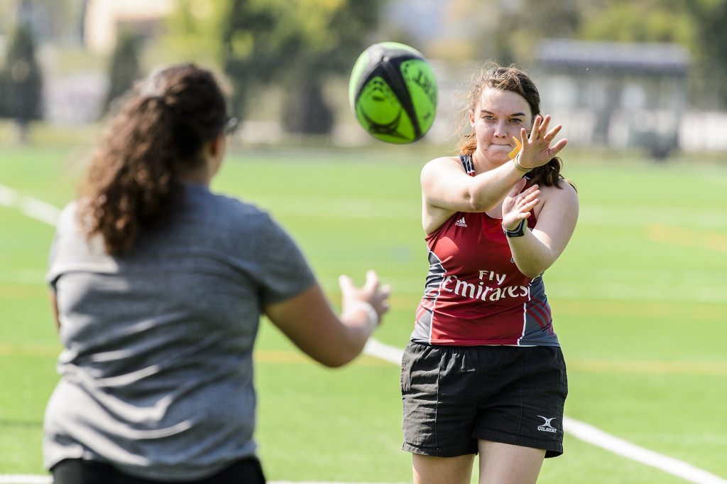 Photo: Two female students playing catch with a rugby ball