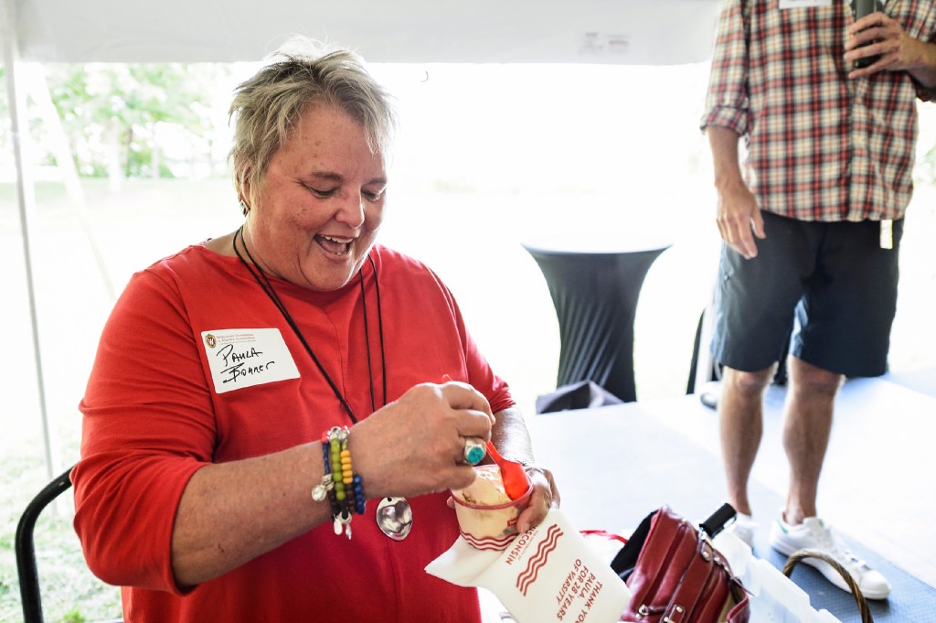 Paula Bonner, retiring executive director of the Wisconsin Alumni Association, samples butter-pecan ice cream (temporarily nicknamed Paula Bon Bon) as she is honored during the Wisconsin Foundation and Alumni Association's annual staff picnic, held on the lawn of the Dejope Residence Hall.