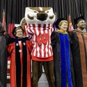 UW Chancellor Rebecca Blank and mascot Bucky Badger link arms and sing 