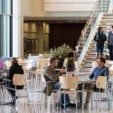 People relax, study and pass through the atrium and nearby Curran Commons inside the School of Nursing's Signe Skott Cooper Hall.