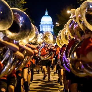 The UW Marching Band performs before thousands of spectators lining State Street during the University of Wisconsin-Madison's Homecoming Parade on Oct. 20, 2017. In the background is the dome of the Wisconsin State Capitol. The annual parade is one of many Homecoming week activities sponsored by the Wisconsin Alumni Association (WAA). (Photo by Jeff Miller / UW-Madison)