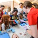 Young participants hold a preserved human brain at a Department of Neuroscience information table as Kendra Taylor (right), research assistant, talks with them during a Saturday Science Event at the Wisconsin Institutes for Discovery in 2015.  A new course aims to help scientists communicate their stories to the epublic.