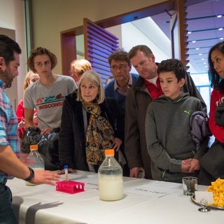 Hagström family of Milwaukee, left, and Telford Family of Chicago, right, listen to the science of cheese making from a professor of food science, Arnoldo Lopez-Hernandez, far left, during the Life of Cheese: A Tasting and Science of Cheese event at Discovery Building's Steenbock's on Orchard Restaurant in Madison, WI. Saturday, Nov. 4, 2017. This event was about an exploration and tasting of cheese as it ages, from cheese curds to Parmesan-Reggiano. This event is put on by the Wisconsin Science Festival and Steenbock’s on Orchard exclusively for Family Weekend, and it was sold-out. (Photo by Hyunsoo Léo Kim | University Communications)