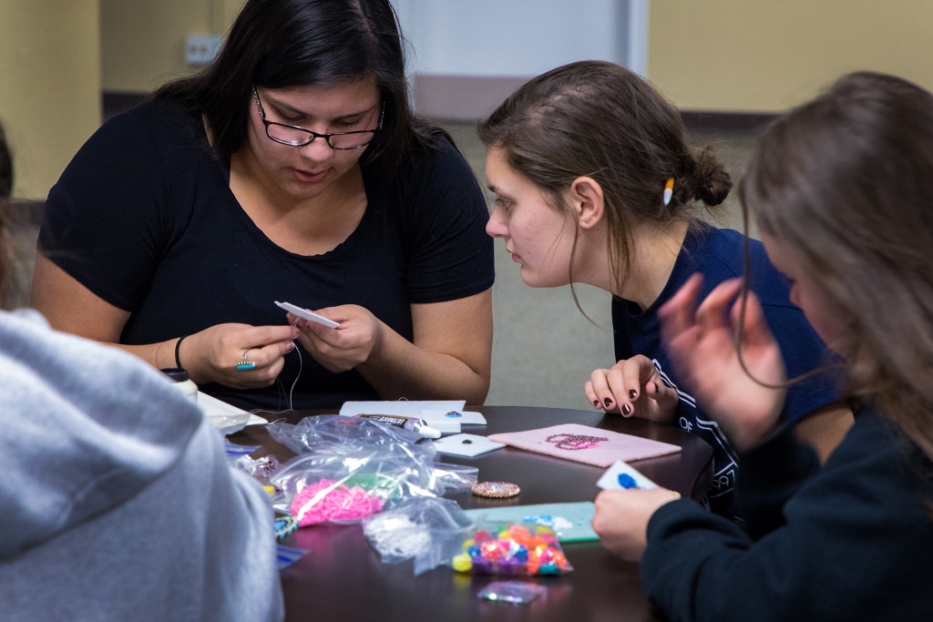 An event open to all, Wunk Sheek student leader Tashya Chevalier demonstrates a beading technique to first-year student Katie Gapinski. To celebrate Native American Heritage Month, student group Wunk Sheek hosted a bead workshop designed to teach contemporary Native American styles at Chadbourne Residence Hall at the University of WisconsinÐMadison in Madison, WI on Tuesday, November 14, 2017. (Photo by Nate Moll | University Communications)