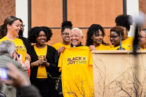 Photo: Nikki Giovanni being presented with T-shirt