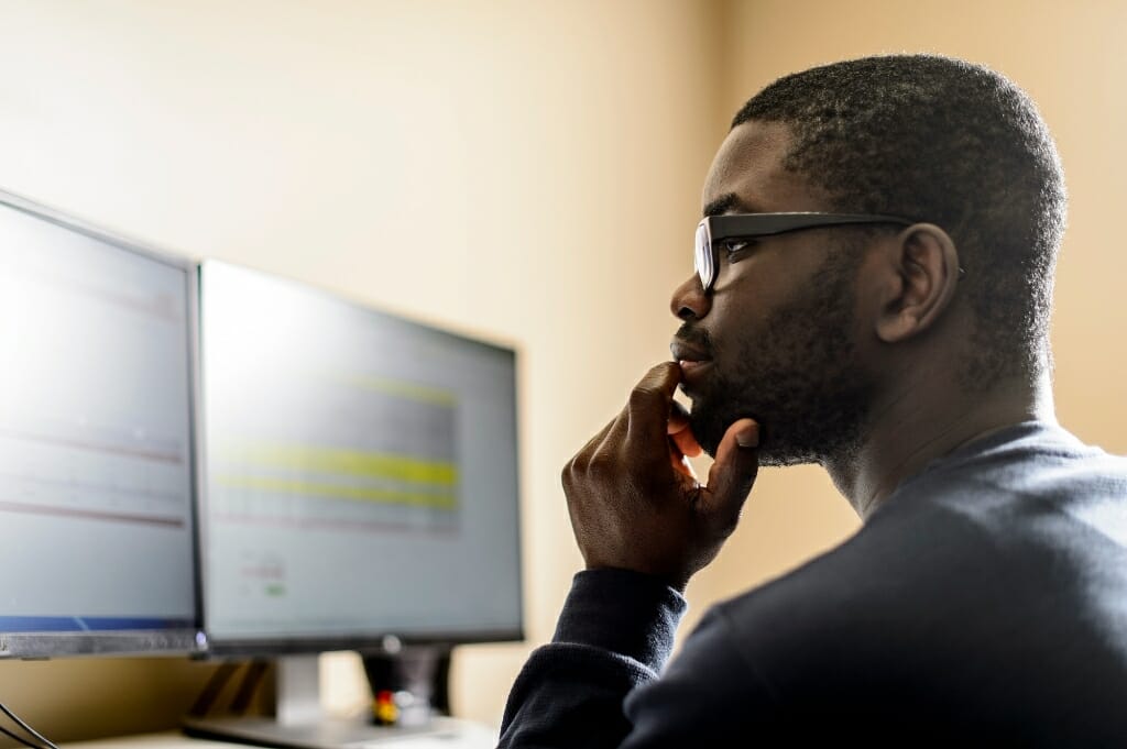 Photo: Kweku Brewoo looking at computer screens