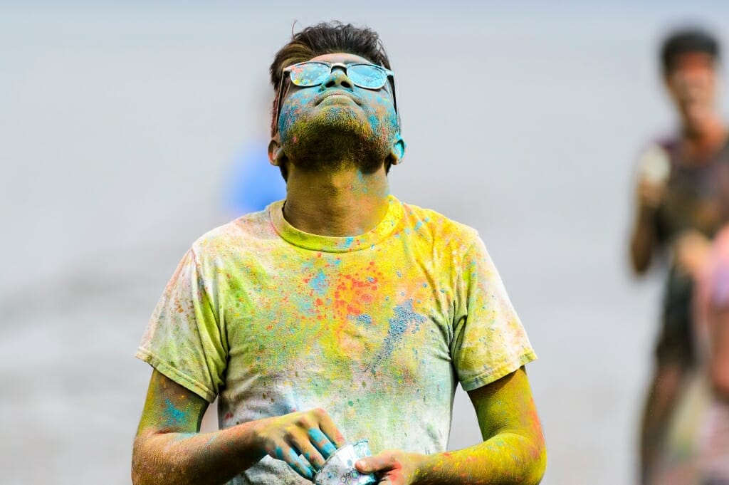 Photo: Man in sunglasses covered with multicolored powder