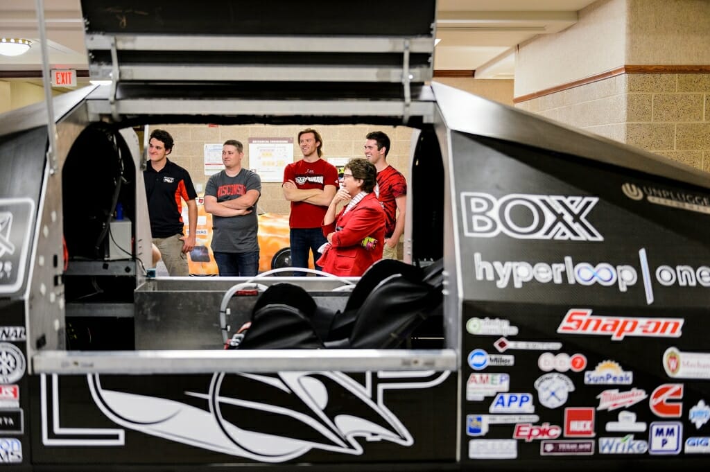 Photo: Students and chancellor seen through opening in Badgerloop vehicle