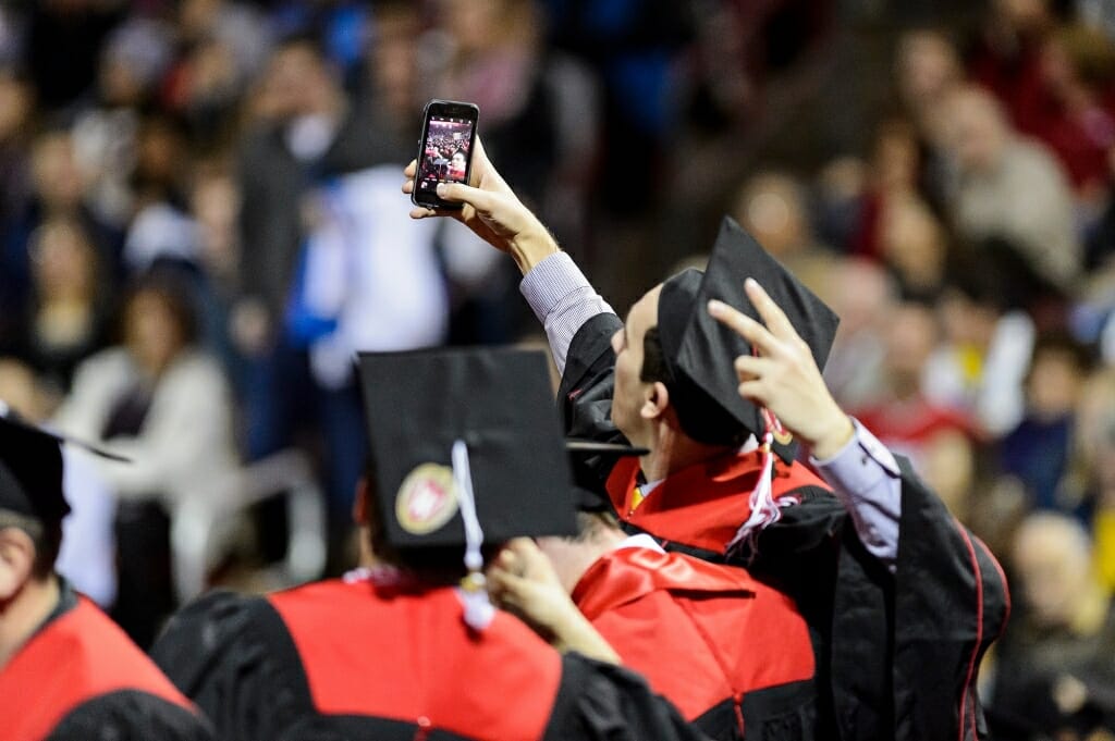 At the chancellor's urging, graduates pose for a selfie.