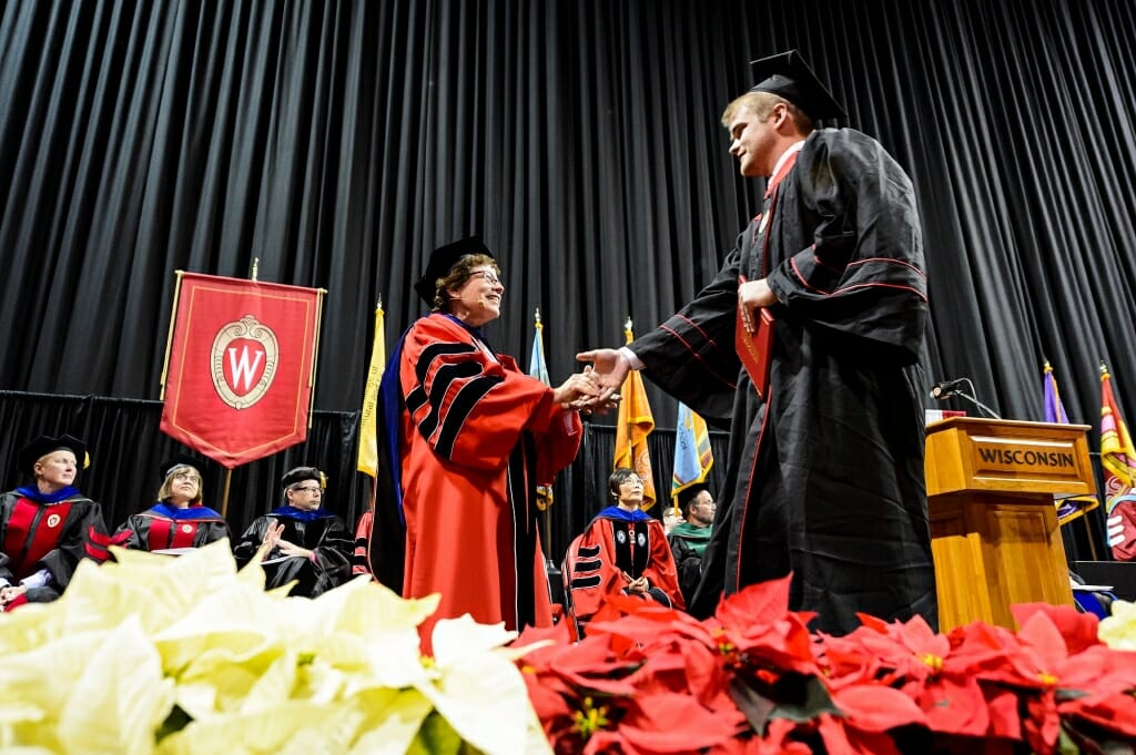Chancellor Rebecca Blank shakes hands with a graduate.