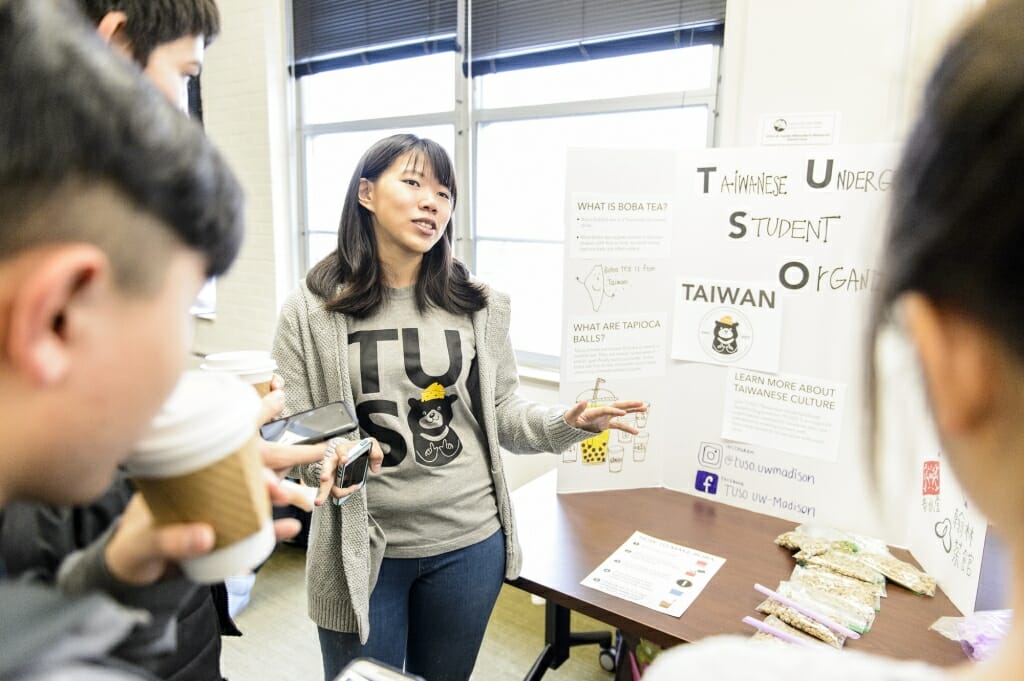 A student member of the Taiwanese Undergraduate Student Organization (TUSO) talks with visitors about Taiwanese culture during a Japanese Student Association (JSA) cultural celebration event inside Ingraham Hall at the University of Wisconsin-Madison on Dec. 2, 2017. The event was a collaborative effort with a number of UW student organizations to promote Asian culture. (Photo by Bryce Richter / UW-Madison)