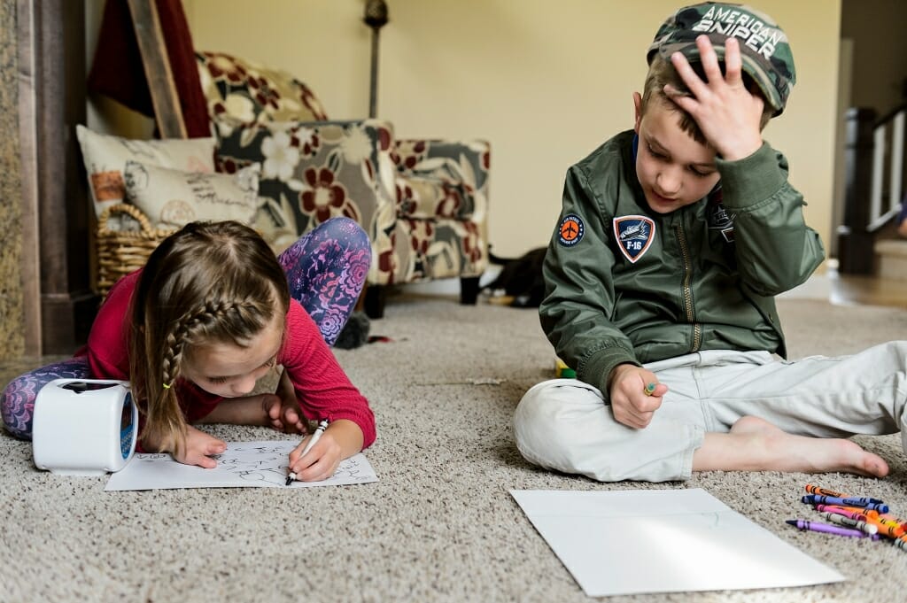 Photo of two siblings coloring.