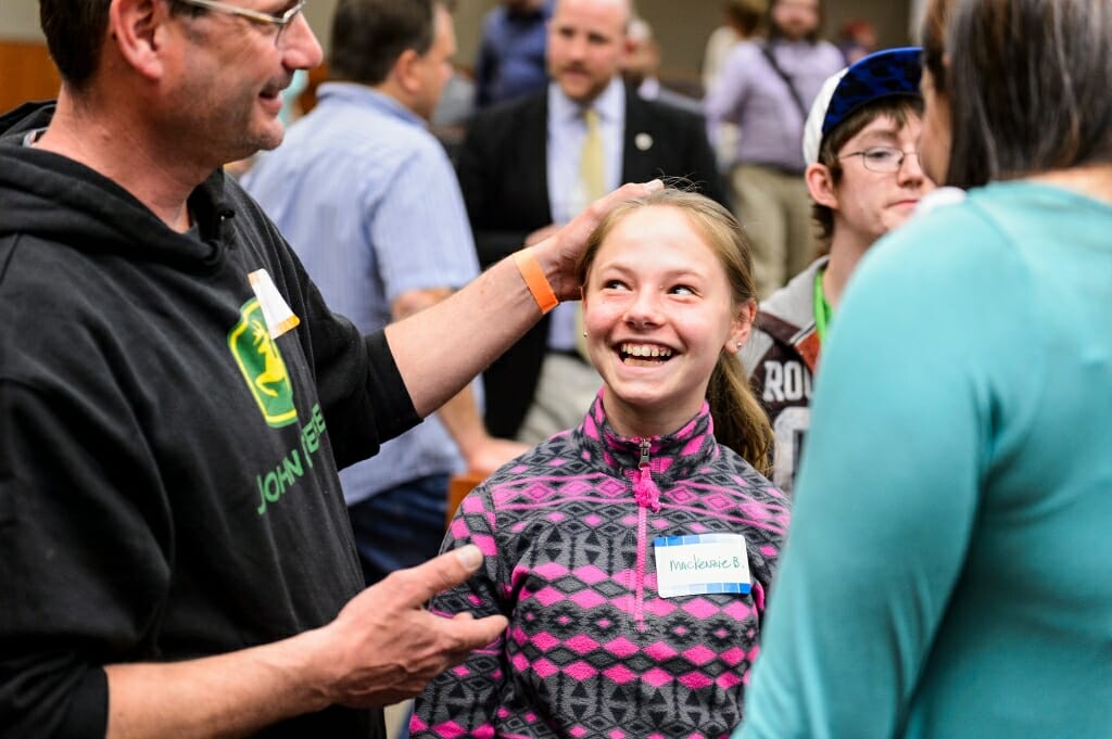 Photo of Larry Britzman and his 11-year-old daughter, Mackenzie, talking to advocate Lindsay Geier during a campus event for patients and their families in May.