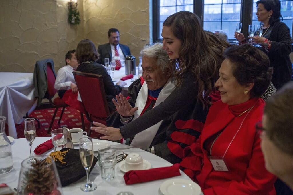 Photo of Barraza, his wife, Martha, and granddaughter Luz Andrea Correa, center, talking to family members who could not attend the ceremony.