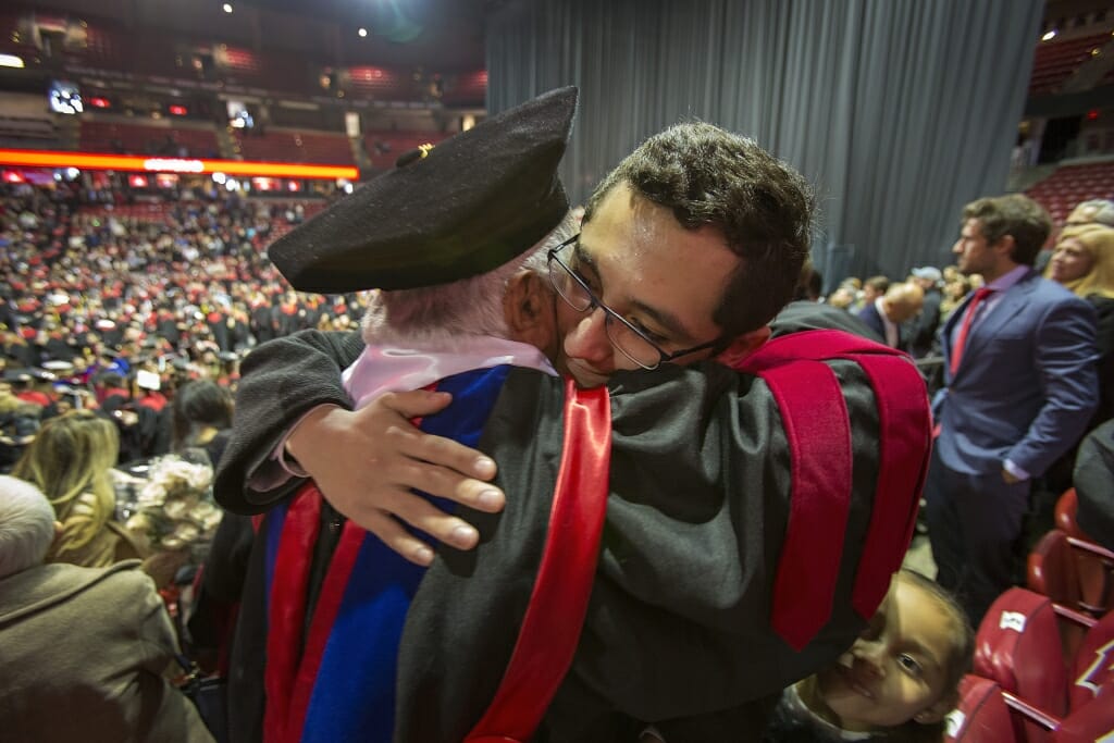 Photo of Barraza embracing his grandson Raul Correa, right, a high school senior in San Antonio, Texas.