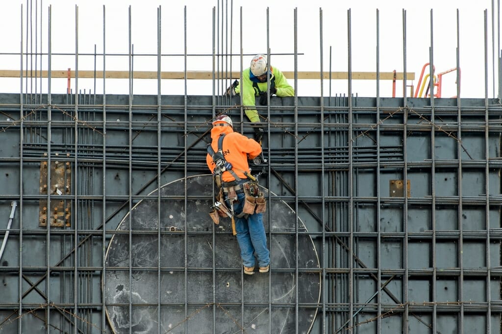 Photo: Workers on scaffold tying rebar