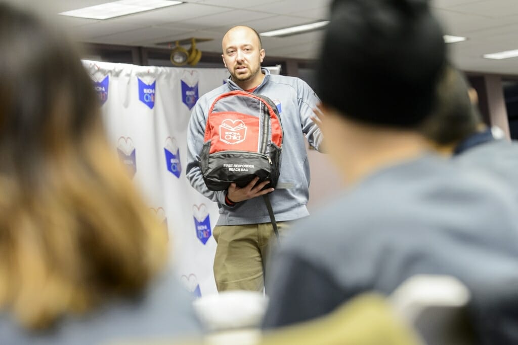 Photo: Eric Salzwedel, marketing and development director for Reach-A-Child, explains the purpose of the backpacks.
