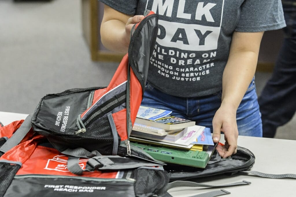 Photo: Person putting books into backpack