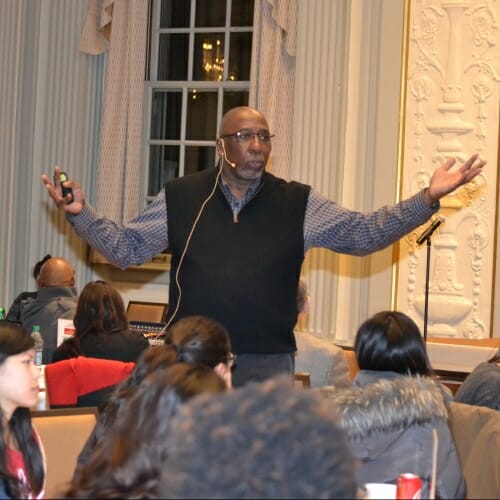 Photo: Tony Porter, arms outstretched, speaking to audience