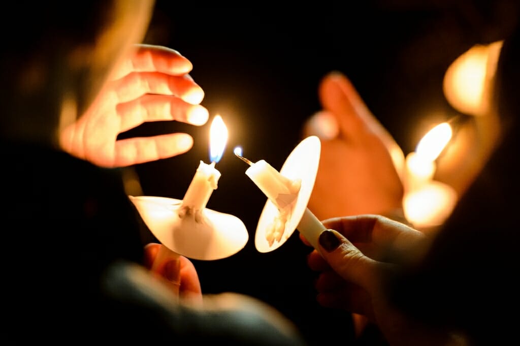 Photo of people lighting candles at a vigil honoring victims of the mass shooting at Marjory Stoneman Douglas High School in Parkland, Florida. The event featured UW students who are graduates of MSD and culminated with a march to the state capitol.