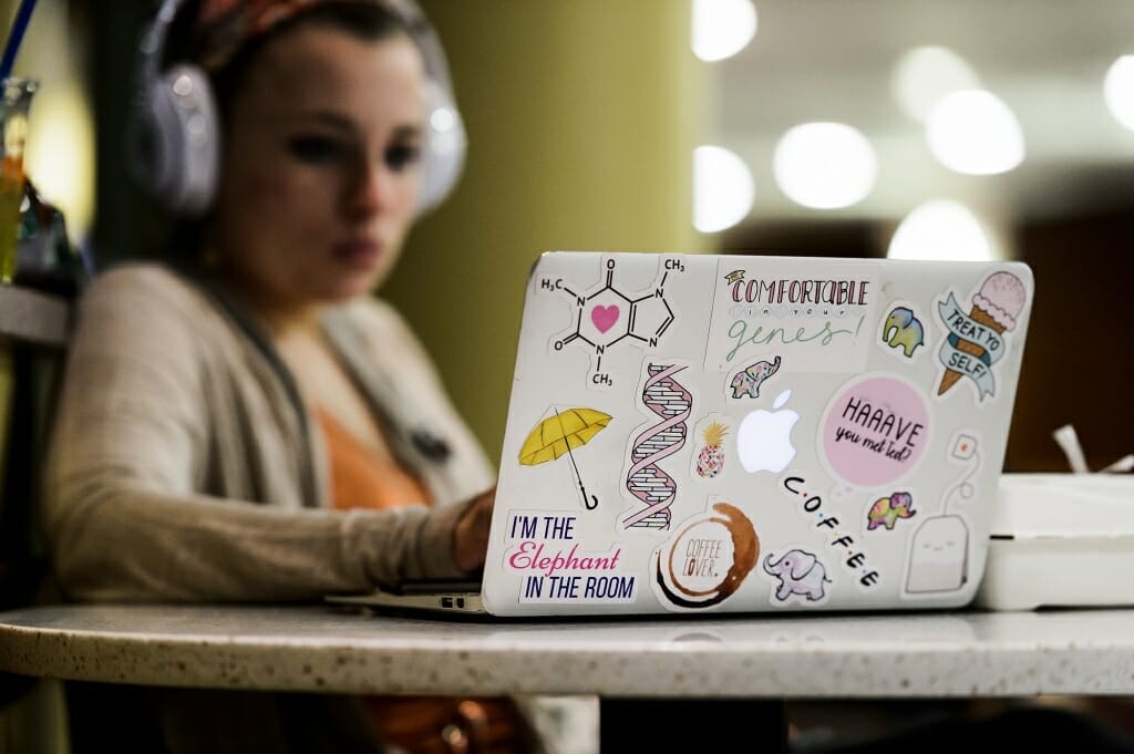 Undergraduate Reagan Stultz uses her sticker-covered laptop to review notes for an upcoming chemistry exam as she studies at Union South.