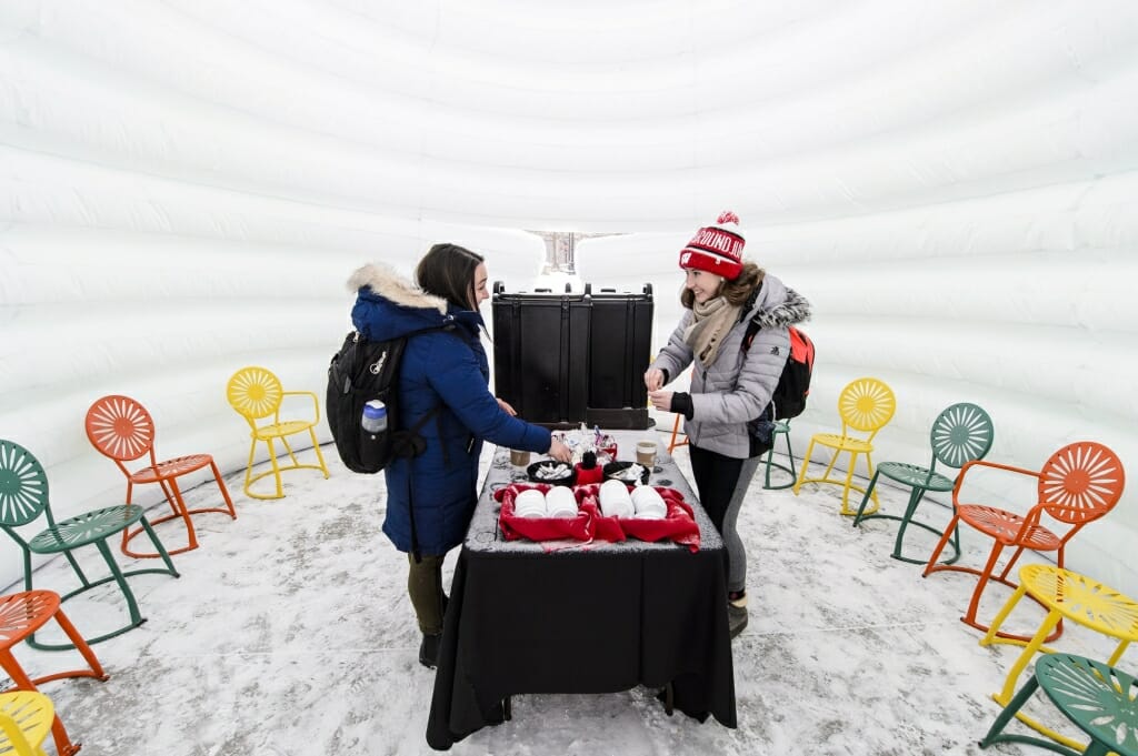 Julia Gutman (left) and Erin Gast (right) enjoy a free cup of coffee during the Hat and Flannel event, part of the annual Hoofers Winter Carnival, at the Memorial Union Terrace on Feb. 5.