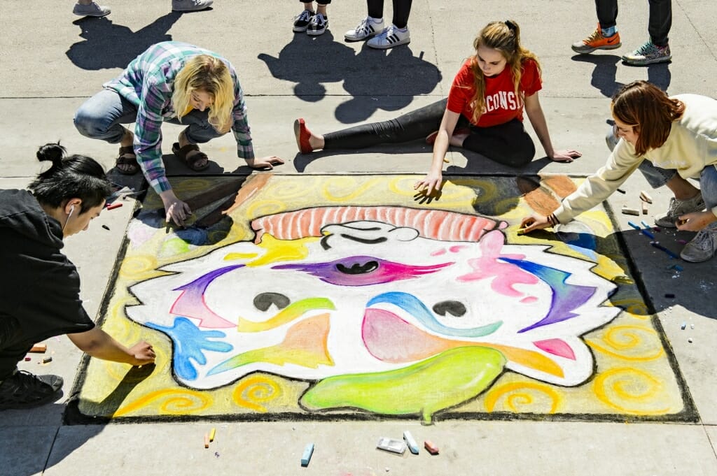 Students work on their chalk art murals featuring Bucky Badger and other campus icons during Badgers Chalk the Block, an All-Campus Party event on Library Mall. 