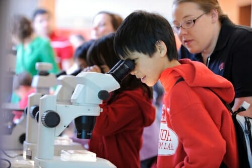 Photo: Young boy looking into microscope