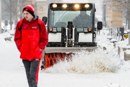 Photo: Snow brush vehicle following pedestrian