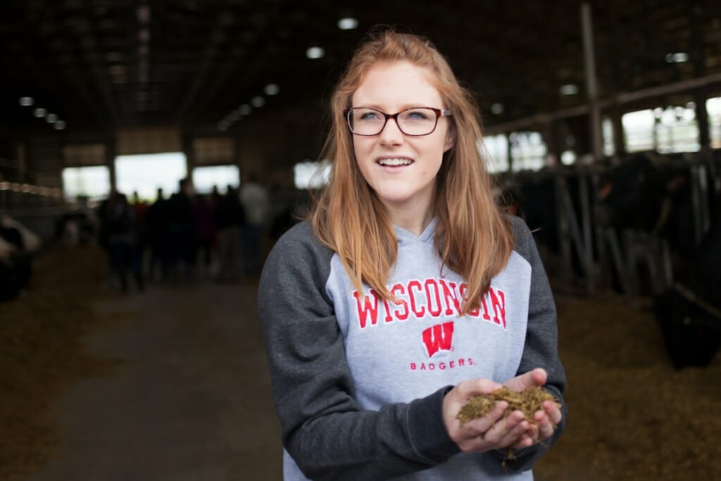 Photo: Allison Breunig holding handful of cattle feed