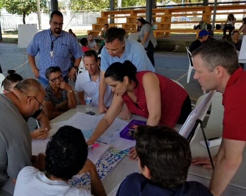 Photo: Group of people around a table looking at a map