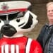 Photo: Kevin Helmkamp standing next to a Bucky statue dressed as a marching band member