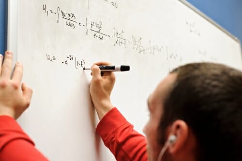 Photo: Person writing on whiteboard
