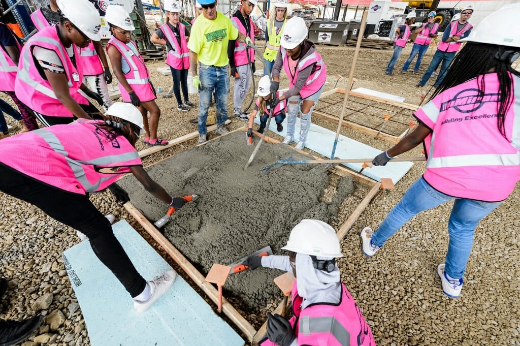 Participants spread and smooth the poured concrete.