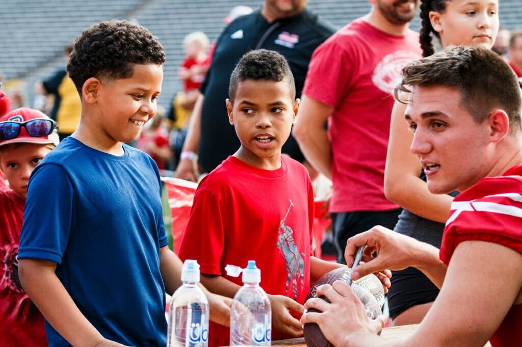 Young fans collect an autograph from tight end Kyle Penniston during Football Family Fun Day.