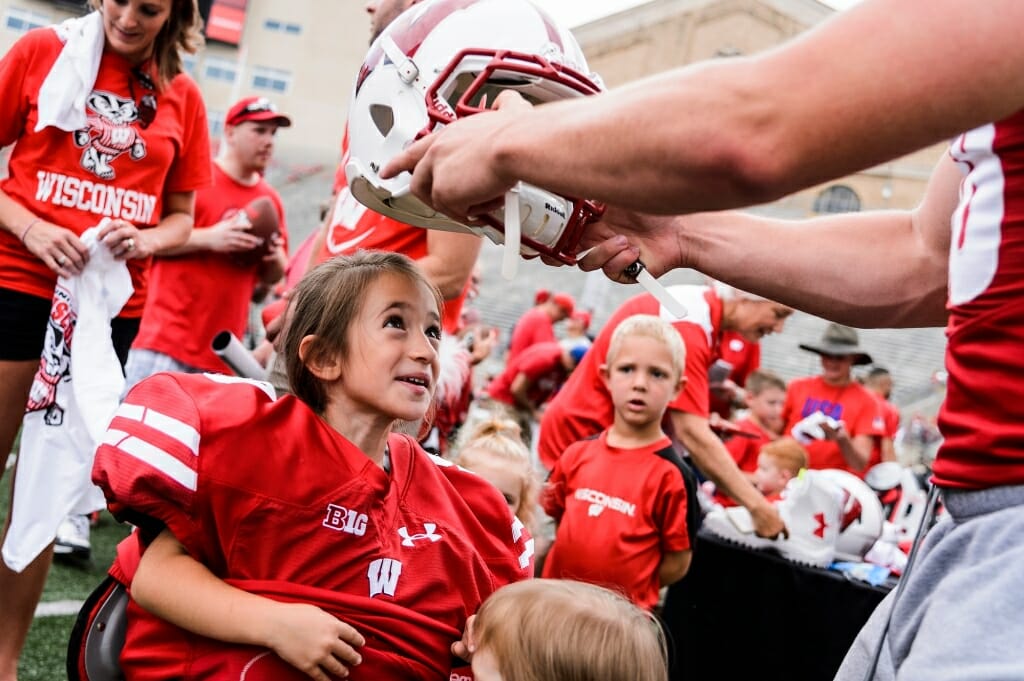 Isabella Stevens, 5, looks up in awe as she tries on shoulder pads and a helmet.