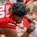 Wisconsin nose tackle Olive Sagapolu (99) signs a fan's shirt.