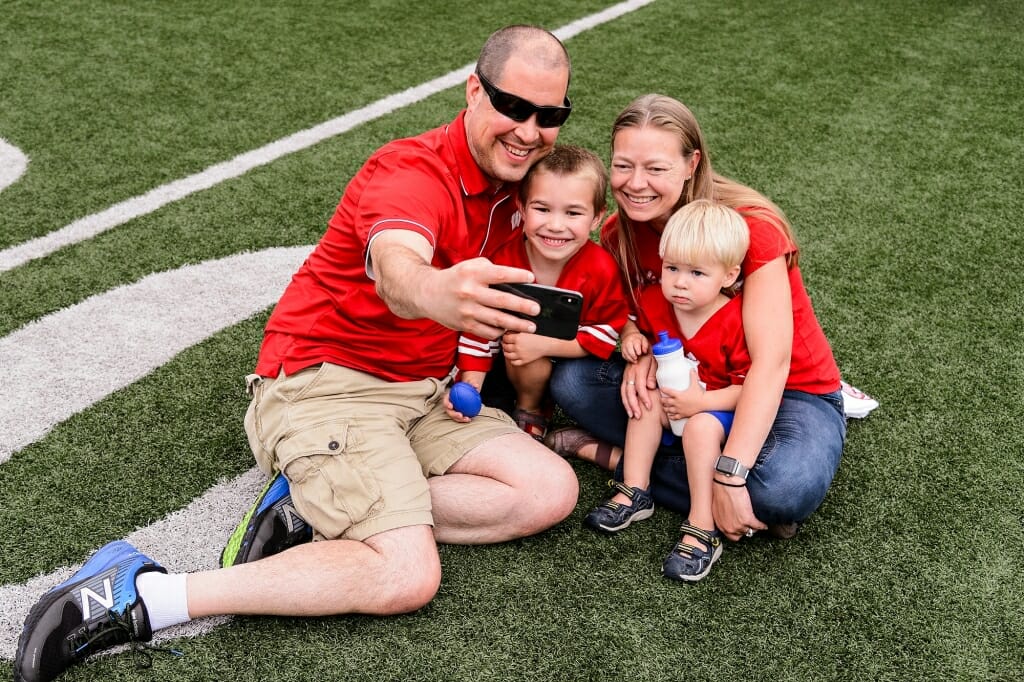 Clockwise from left, Dave, Val, Vin and Nat Schroeder pose for a family photo on the field at Camp Randall Stadium.