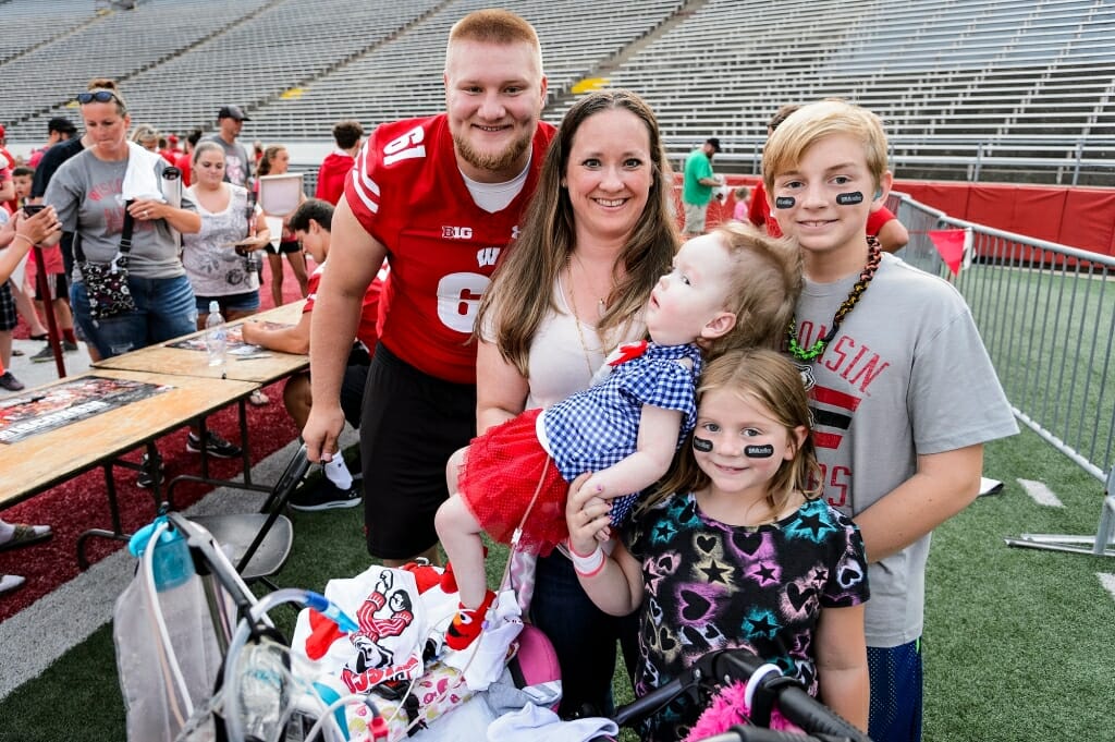 Wisconsin outside linebacker Tyler Biadasz (61) poses for a photo with mother Nicole Fritz and her children Leani (being held), J.R., and Daisy. Leani has spinal muscular atrophy and is a patient at the American Family Children's Hospital at UW-Madison.