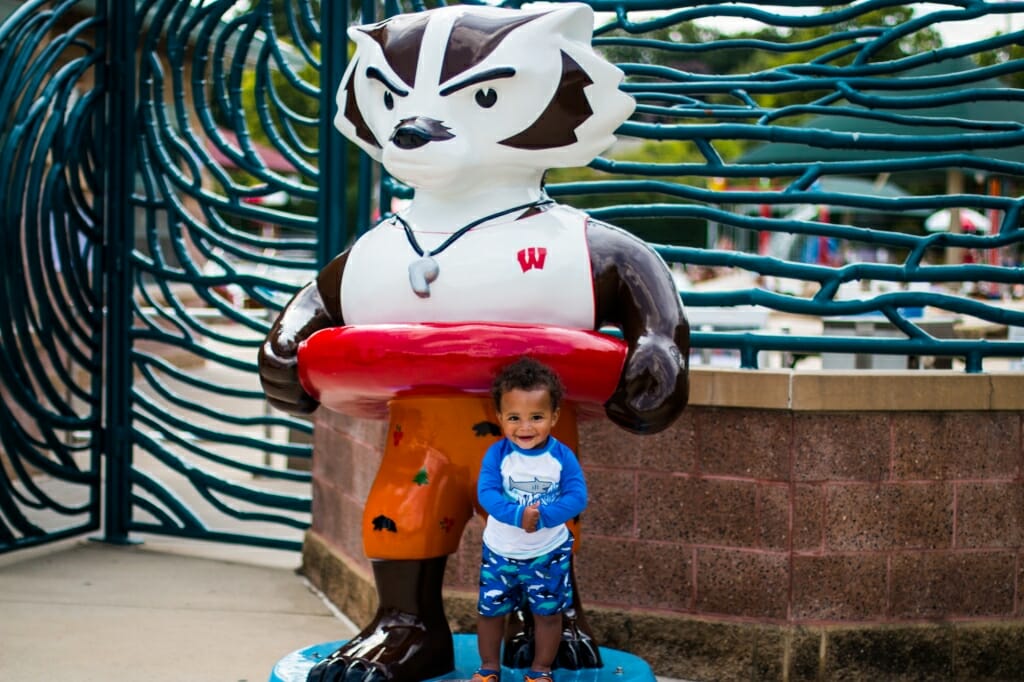 A young child poses with a Bucky that looks like a lifeguard.
