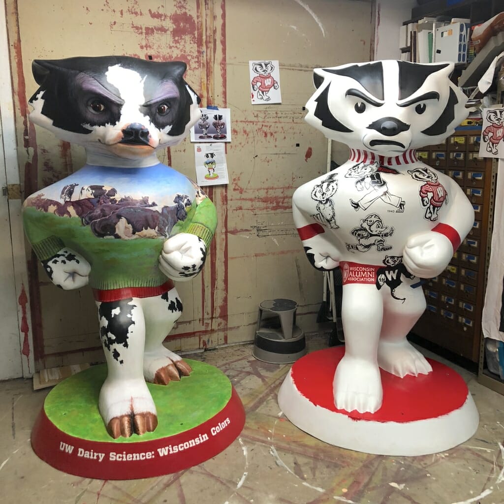An unfinished Retro Bucky stands next to Wisconsin Colors, which Medaris also designed. Wisconsin Colors depicts the green pastures and cows that are core to Wisconsin's identity. 