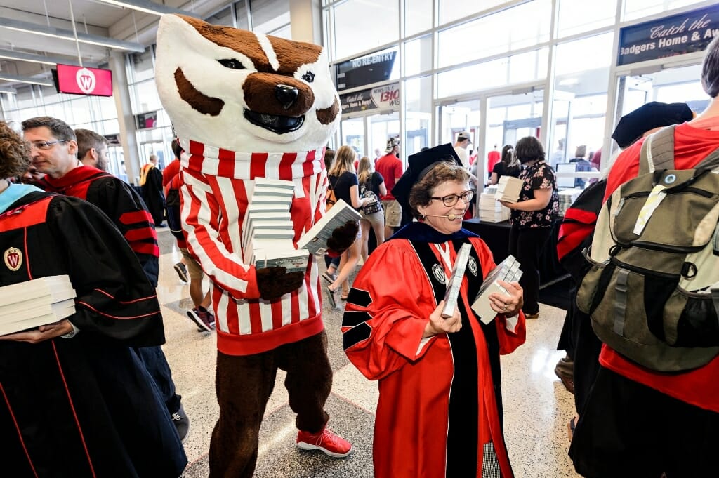 Bucky Badger and Chancellor Rebecca Blank help volunteers distribute complimentary copies of 
