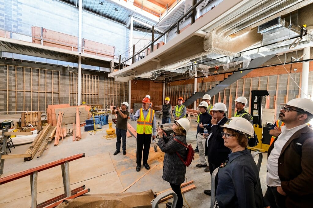 Wearing a red hardhat, Malcolm Holzman, founding partner of the architectural design firm Holzman Moss Bottino Architecture of New York, describes the features of Collins Recital Hall.