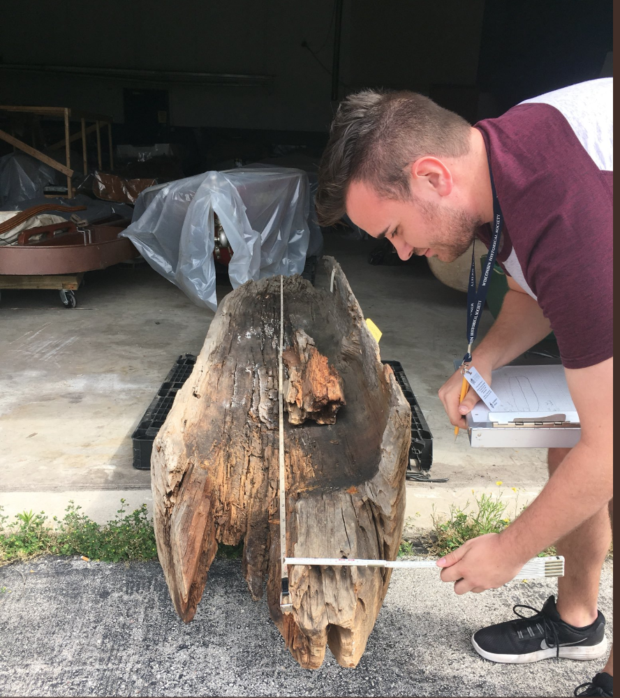 Ryan Smazal measures a dugout canoe for his research project.