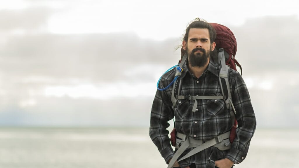 Jackson Parr with a backpacking pack poses during a cloudy day before his trek across the U.S. 