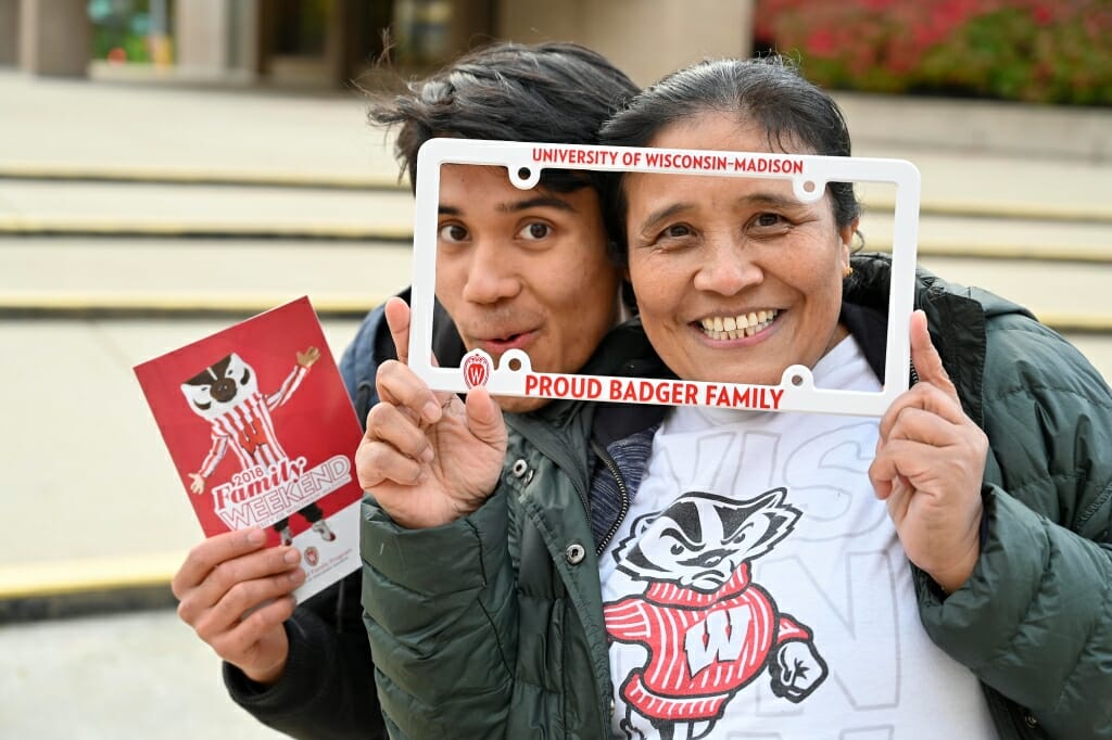 Mother and son pose behind a license frame.